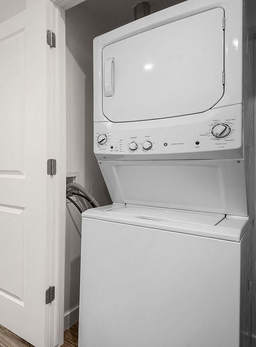 A white door is open to a kitchen with a dishwasher and a microwave.