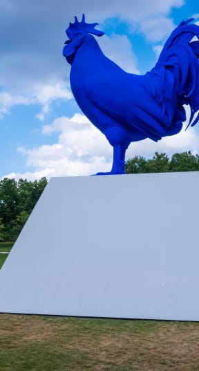 a giant rooster statue in a park at The Park Apartments in Minneapolis, MN