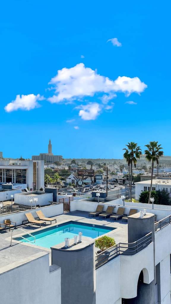 A rooftop pool area with a view of the city skyline. at Midvale Court Apartments Westwood, Los Angeles