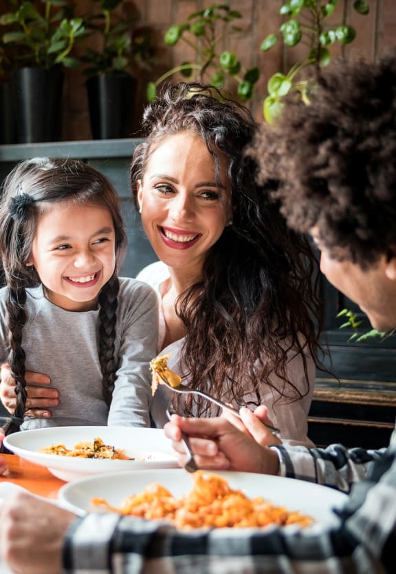 This is a photo pf a family at the dinner table. at The Brownstones, Dallas, 75240