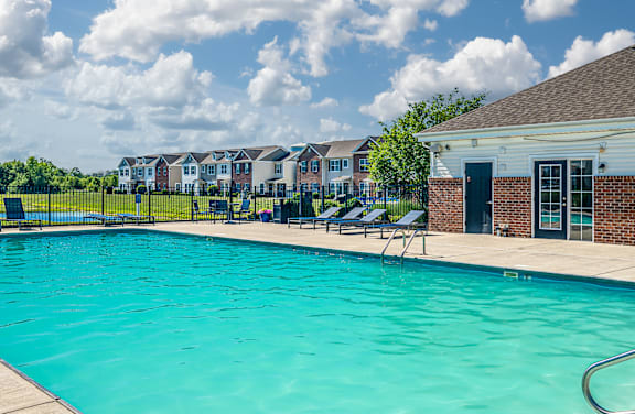 A large swimming pool surrounded by lounge chairs and umbrellas.