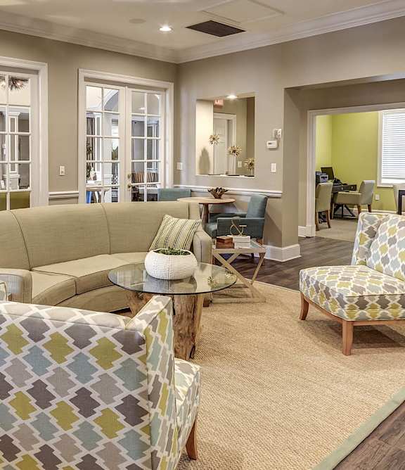 A living room with a couch, chairs, and a rug at Heritage Cove Apartments in Stuart, FL, 34997