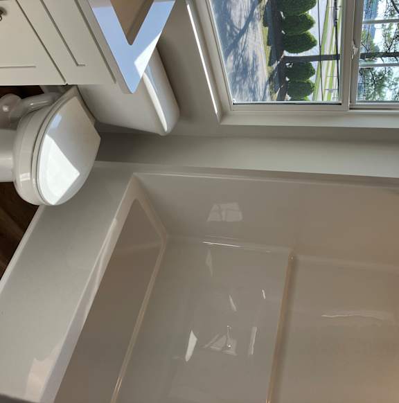A white ceiling with a window and a white air conditioner unit.