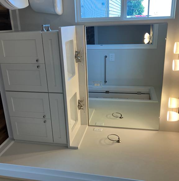 A bathroom with a mirror, light fixture, and a toilet.