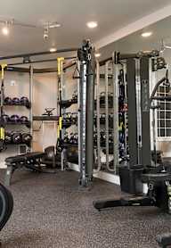A gym with a variety of equipment including treadmills, weights, and exercise machines.