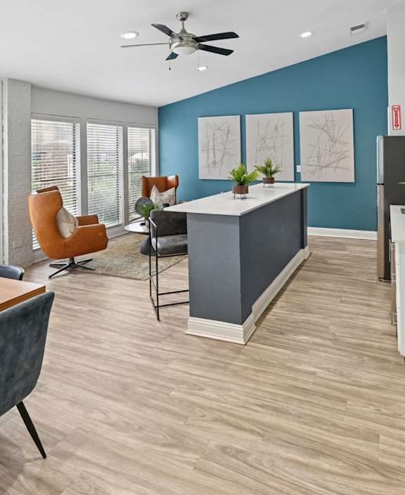 A modern living room with a wooden table and blue chairs.