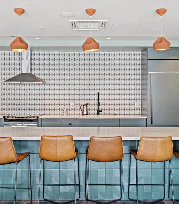 A kitchen with a bar area and chairs.