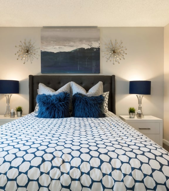 a blue and white bed with pillows in a bedroom