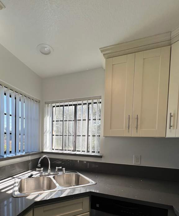 A kitchen with a stainless steel oven and white cabinets.