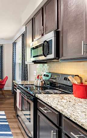 A kitchen with a red chair and a counter top.