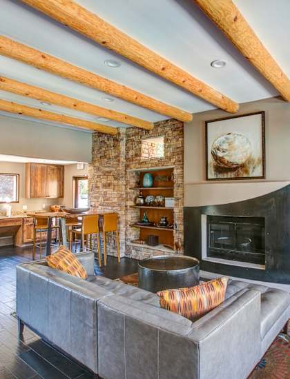 A living room with a grey couch and a fireplace.