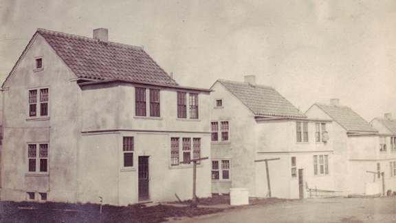 A black and white photo of a house with a sleeping porch.