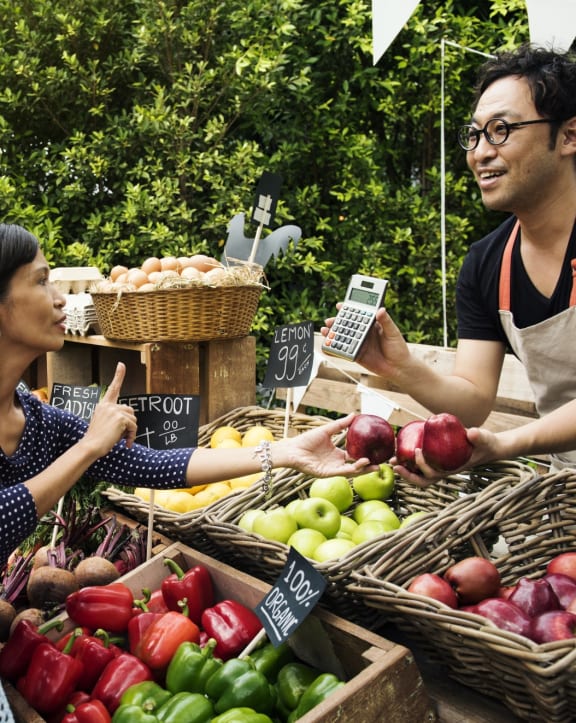 Man Selling Woman Food at Farmers Market