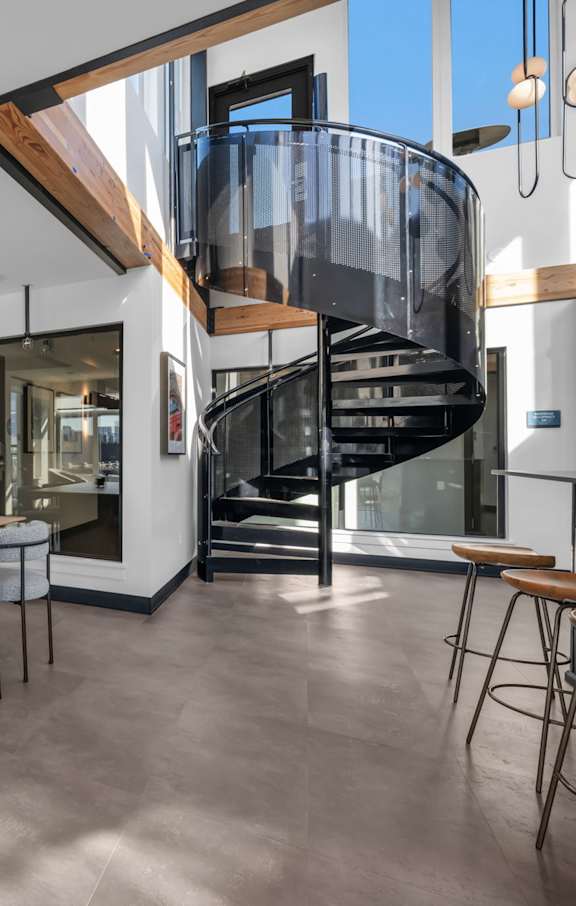 A modern open-plan living space with a spiral staircase.