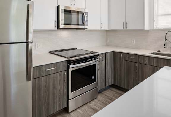 A modern kitchen with a stainless steel refrigerator and a white countertop.