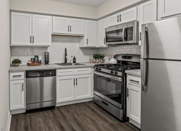 an empty kitchen with stainless steel appliances and white cabinets at Rushwood Apartments, Philadelphia, Pennsylvania