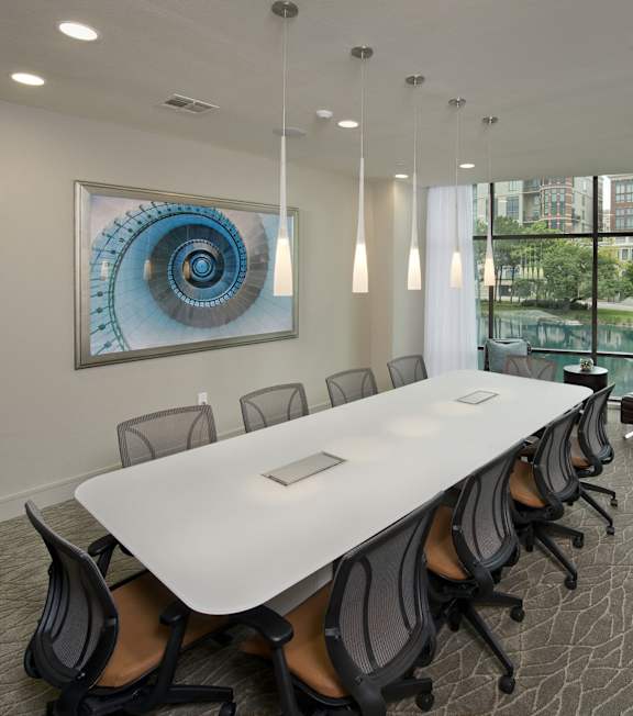 A conference room with a large table and chairs.