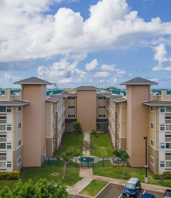 a large apartment building with a parking lot and palm trees