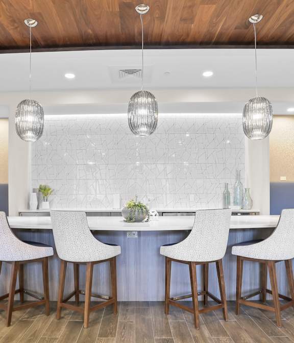 A modern dining room with a wooden table and grey chairs.