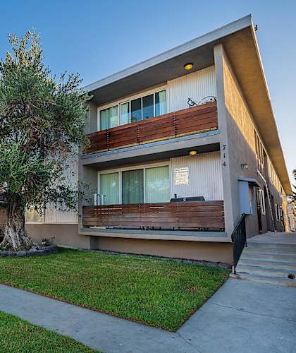 A modern house with a tree in front of it.