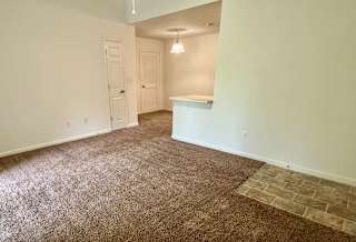 an empty living room with a carpeted floor and white walls at Shenandoah Properties in Lafayette, IN 47905