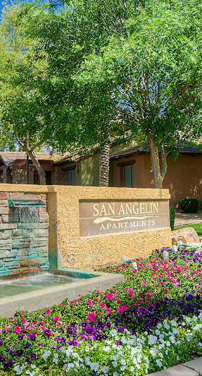 A sign that says San Clemente sits in front of a wall of flowers.