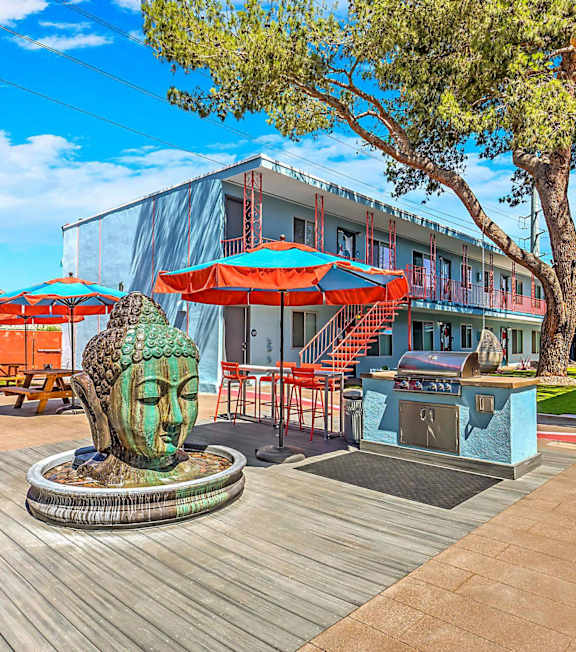 A sculpture of a face sits in the middle of a wooden deck.