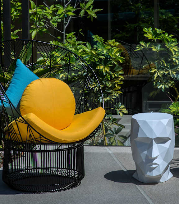 Two yellow chairs with blue pillows are placed outside.