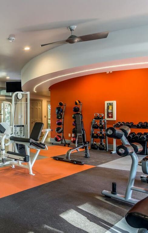 a gym with weights and cardio equipment in a home with a large window at The Atlantic Vinings, Smyrna, Georgia