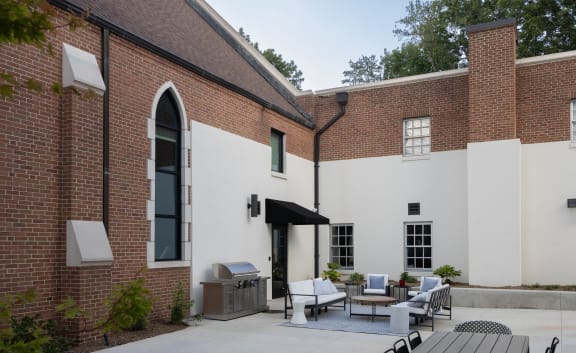 the courtyard of a brick building with tables and chairs