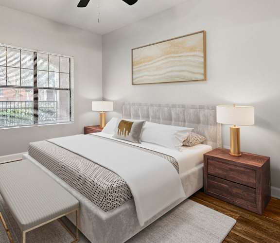 A bedroom with a bed, nightstand, and a plant at Crogman School Lofts in Atlanta, GA 30315