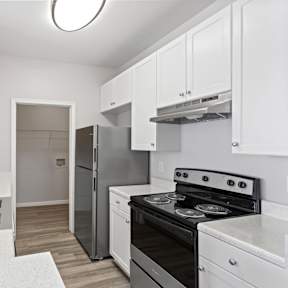 A modern kitchen with white cabinets and stainless steel appliances.
