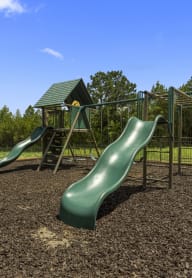 a playground with two slides and a jungle gym