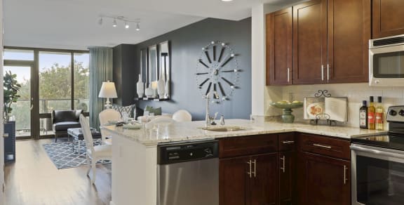 a kitchen with a large center island with a breakfast bar and a living room in the background at Aurora apartment in North Bethesda, Maryland