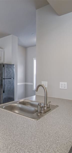 a kitchen with white cabinets and a black stove and refrigerator