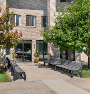 a sidewalk with benches and a sign in front of a building