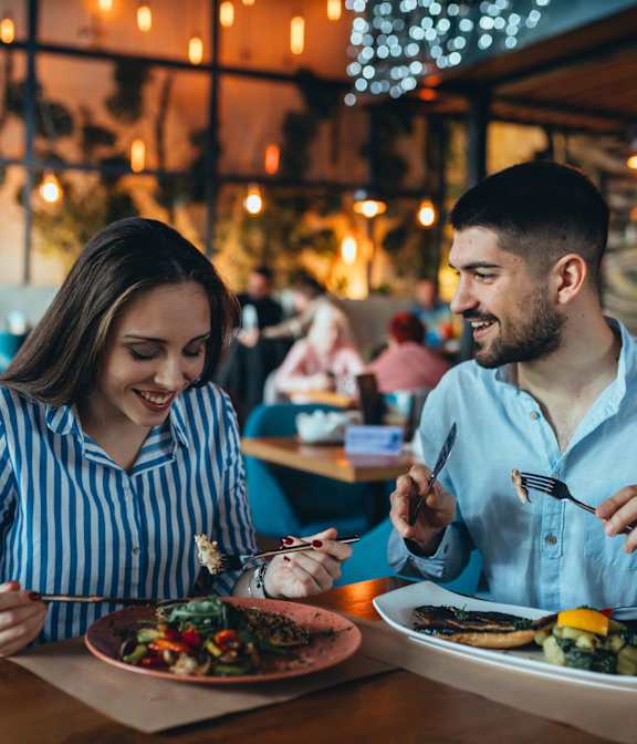 A man and a woman are enjoying a meal together in a restaurant.