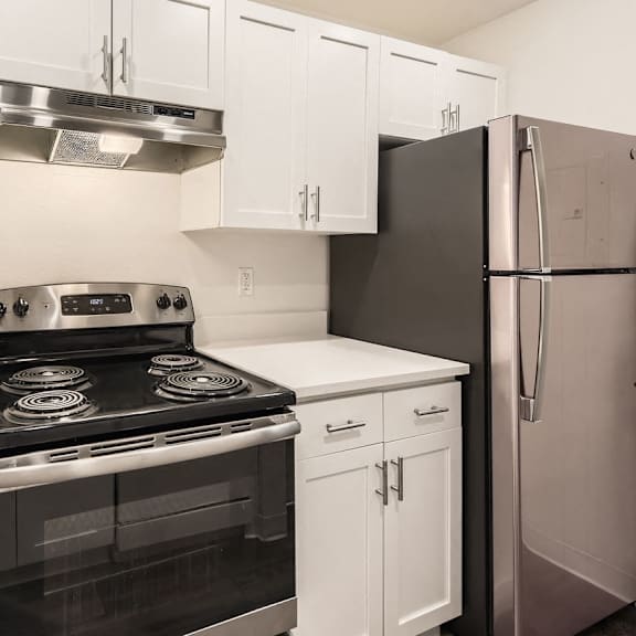 A kitchen with white cabinets and a black stove top oven.