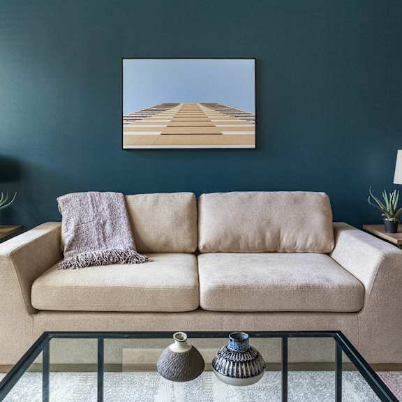 A living room with a stone fireplace and a chair with a patterned cover.at Riverview Landing @ Valley Forge, Eagleville Pennsylvania