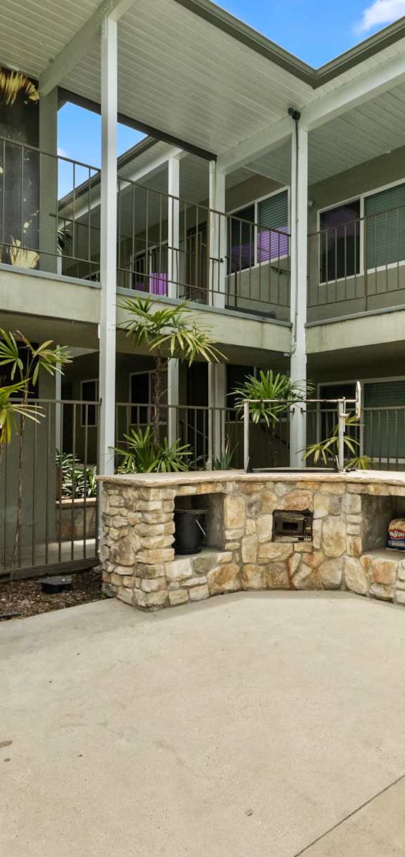 A courtyard with a stone fireplace and a wall mural.