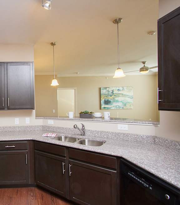 A kitchen with brown cabinets and a black stove top oven.