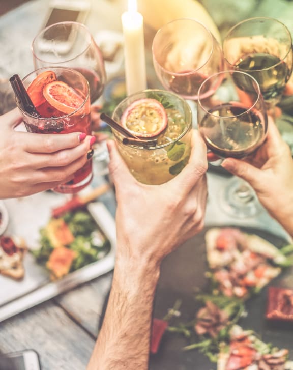 a group of people holding up wine glasses over a table