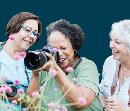 Three women are taking a photo with a camera.