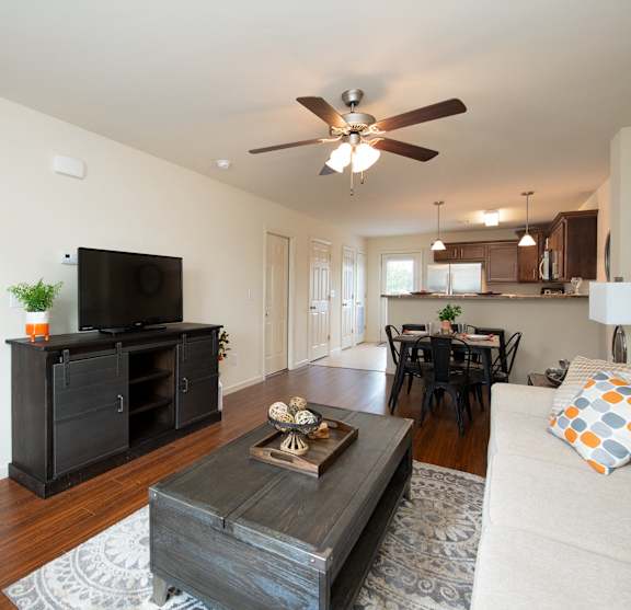 A living room with a television, a couch, and a coffee table.