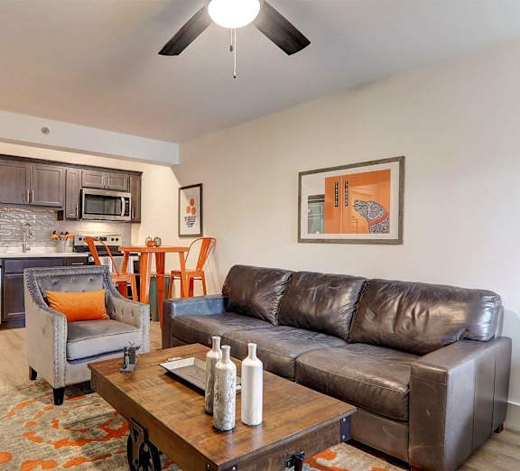 A modern kitchen with a refrigerator, microwave, and oven.