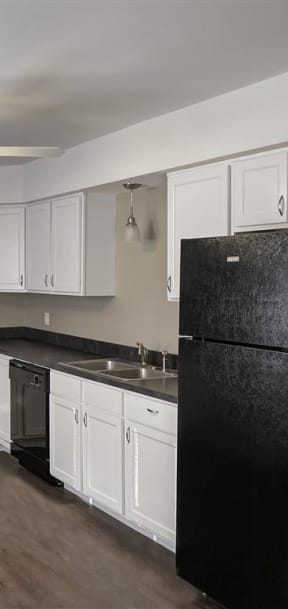 a kitchen with white cabinets and a black stove and refrigerator