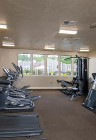 a room filled with lots of cardio equipment and a flat screen tv