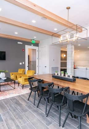 a living room with a wooden table and chairs and a television at Emblem Alpharetta, Alpharetta, GA