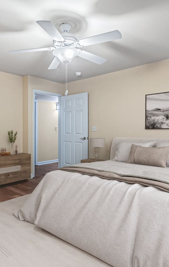 a living room with a kitchen and a ceiling fan