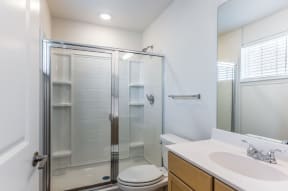a bathroom with a shower and a sink and a toilet